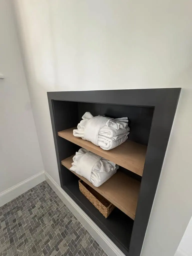 Folded white towels arranged on bathroom shelves