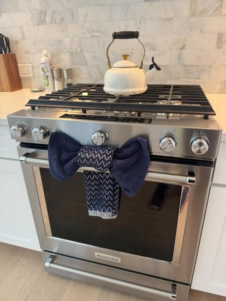Clean stainless steel range with a kettle and neatly folded towel