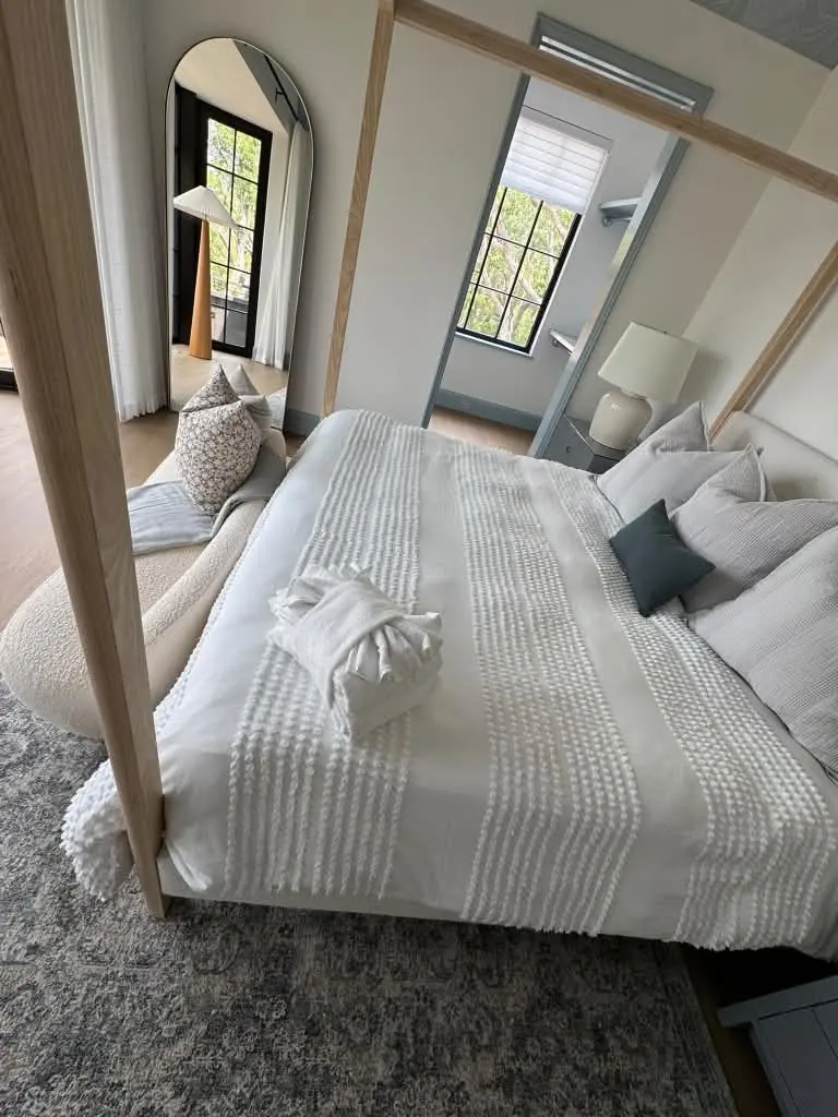 Freshly made white bed with folded towels